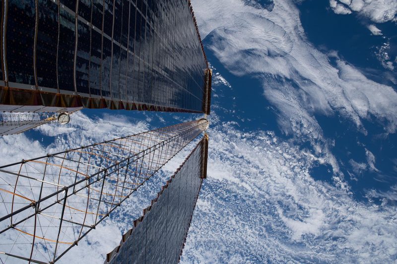 The International Space Station's new roll-out solar arrays seen against Earth