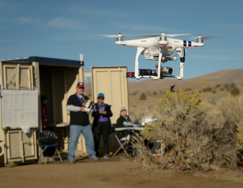 Several drones fly at different heights over a field in a NASA traffic management test