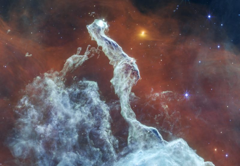 A glowing cloud of gas and dust shaped like a cat's head, seen by the Webb telescope